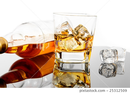 glass of whiskey near bottle and ice cubes on black table with reflection glass of whiskey near bottle and ice cubes on black table with reflection 25312509