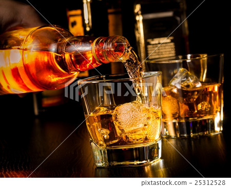 barman pouring whiskey in front of whiskey glass and bottles barman pouring whiskey in front of whiskey glass and bottles 25312528