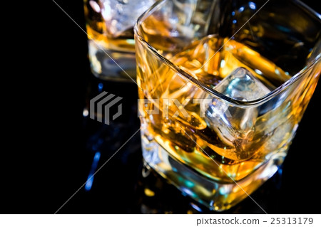 close-up of top of view of glass of whiskey on black table with reflection 25313179