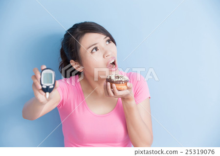 woman holding blood glucose meter woman holding blood glucose meter 25319076