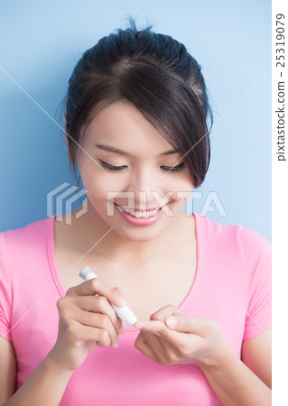 woman holding  blood glucose meter 25319079