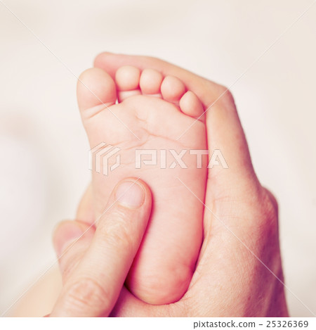 Male hand with baby feet, parental care 25326369