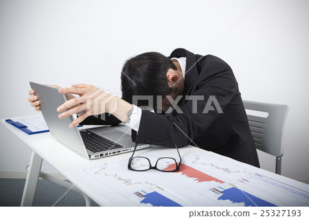 A businessman dropping a shoulder in front of a personal computer A businessman dropping a shoulder in front of a personal computer 25327193