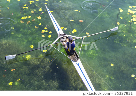 A Young single scull rowing competitor paddles A Young single scull rowing competitor paddles 25327931