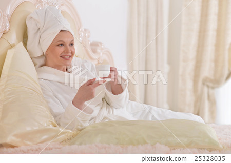 young woman wearing a white bathrobe 25328035