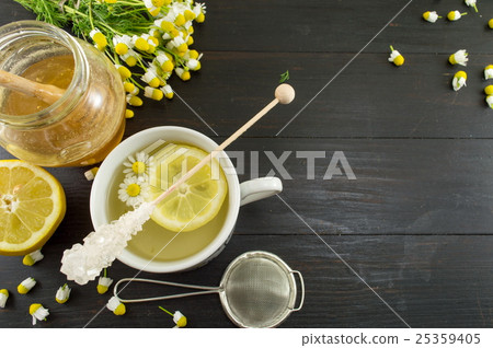 Chamomile tea with lemon slice and flowers 25359405