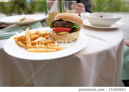 Hamburger and fries at restaurant table 25360601