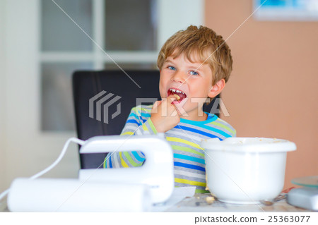 Happy blond kid boy baking cake indoors Happy blond kid boy baking cake indoors 25363077