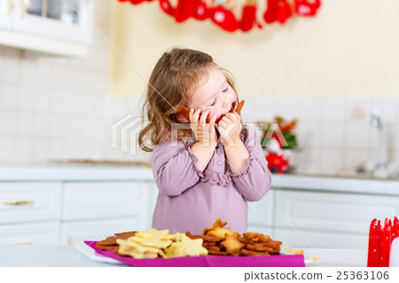 Little girl baking gingerbread cookies on 25363106