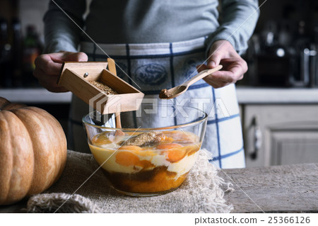 Adding spices in the dough for pumpkin dump cake Adding spices in the dough for pumpkin dump cake 25366126