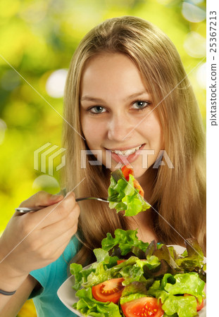 Young woman eating salad 25367213