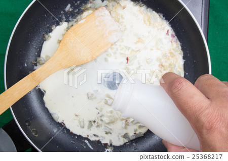 Chef pouring fresh milk to the pa 25368217
