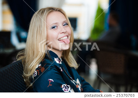 Beautiful blond-brown girl showing tongue and Beautiful blond-brown girl showing tongue and 25370703