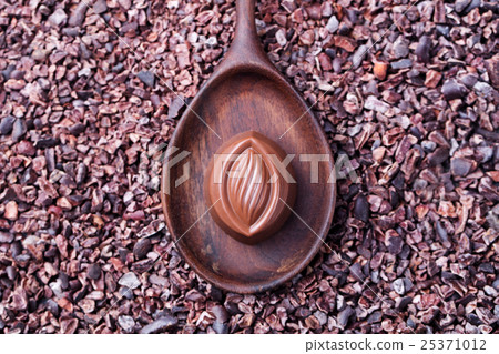 Chocolate candy in a wooden spoon 25371012