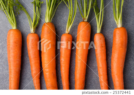 Fresh carrots bunch on a grey stone background. 25372441