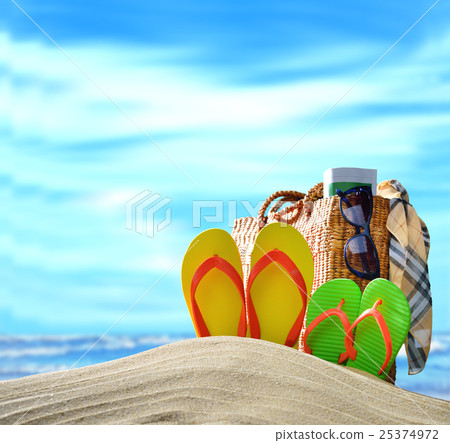 Beach accessories on sandy beach with blue sea 25374972