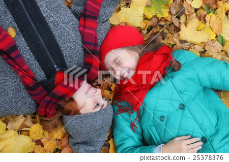 daughter and mother lay on a ground leaves autumn daughter and mother lay on a ground leaves autumn 25378376