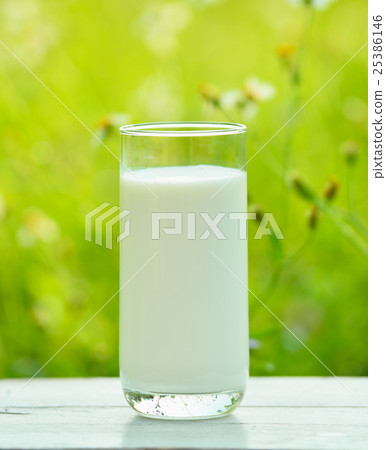 Glass of milk  on white  table  in morning garden 25386146