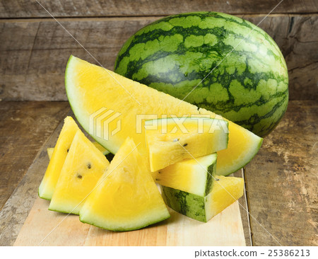 Yellow watermelon  sliced on wooden background 25386213