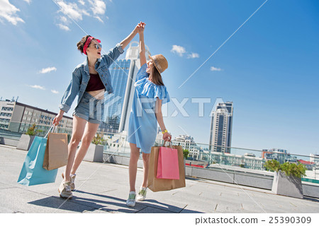 women after shopping walking with purchases and women after shopping walking with purchases and 25390309