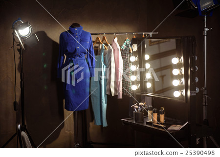 Stylish clothes and make-up products in dressing 25390498