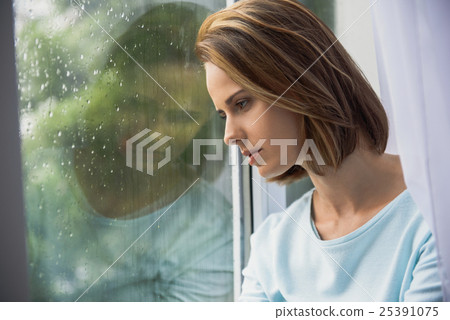 sad woman sitting indoors while raining sad woman sitting indoors while raining 25391075