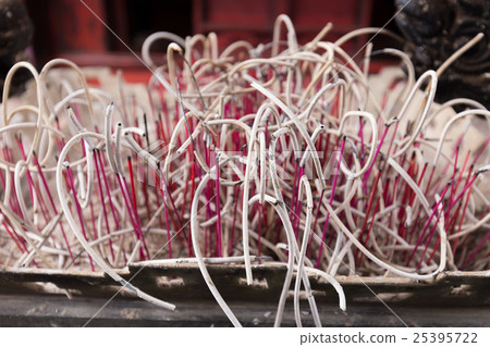 Close focus on red bending burned incense sticks 25395722