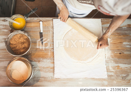 Chef preparing dough in a kitchen. 25396367