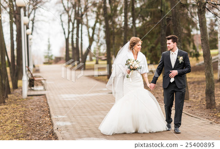 happy bride and groom walking in the autumn park happy bride and groom walking in the autumn park 25400895