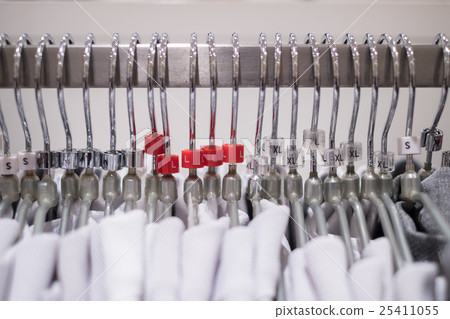 Clothes hang on a shelf in a modern clothes store. Clothes hang on a shelf in a modern clothes store. 25411055