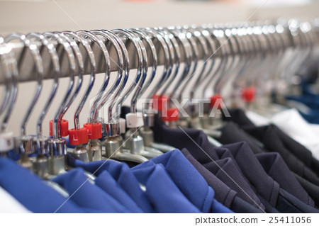 Clothes hang on a shelf in a modern clothes store. Clothes hang on a shelf in a modern clothes store. 25411056