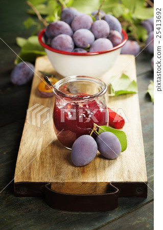 Plums and jar of jam on table Plums and jar of jam on table 25413692