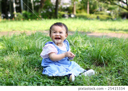 Baby in blue clothes laughing in the park 25415334