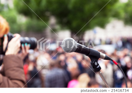 Microphone in focus, blurred female photographer  25416734