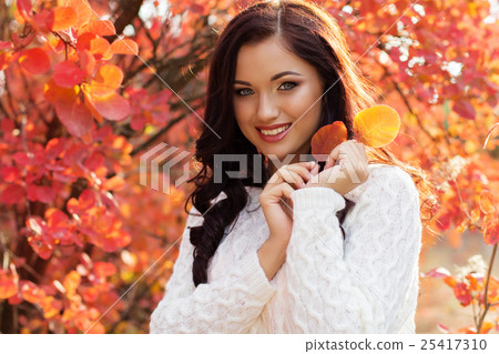 Beautiful smiling girl in colorful autumn leaves 25417310