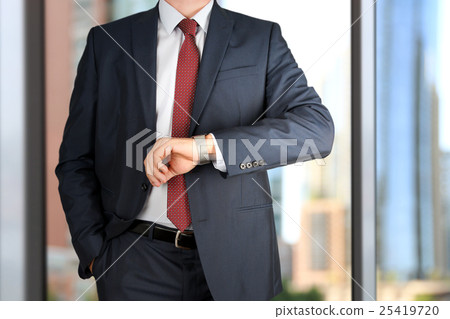 businessman checking time on his watch at office 25419720