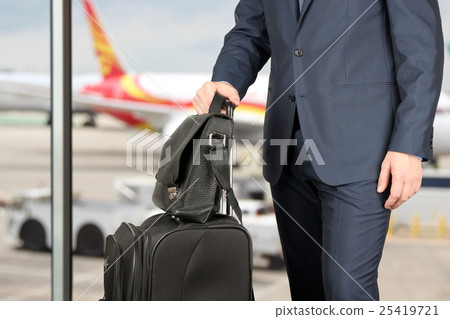 man in a stylish suit with luggage in the airport 25419721