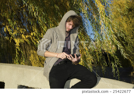 Teenager reading electronic book in the park  25422677