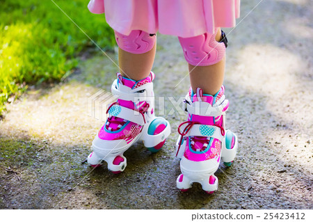 Little girl with roller skate shoes in a park 25423412