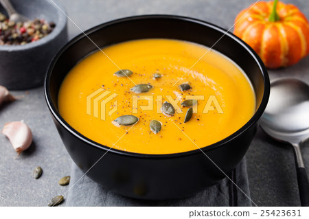 Pumpkin cream soup, pumpkin seeds in a black bowl. Pumpkin cream soup, pumpkin seeds in a black bowl. 25423631