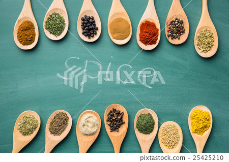 Various spices in wooden spoons. 25425210