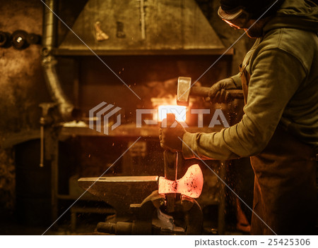 The blacksmith forging the molten metal on the 25425306