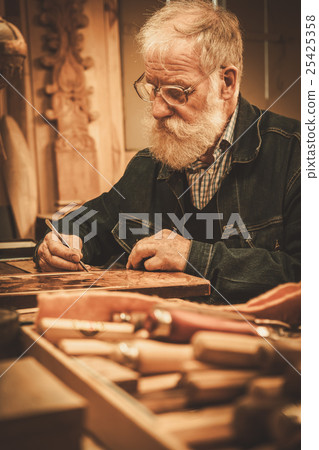 Senior restorer working with antique decor element Senior restorer working with antique decor element 25425358
