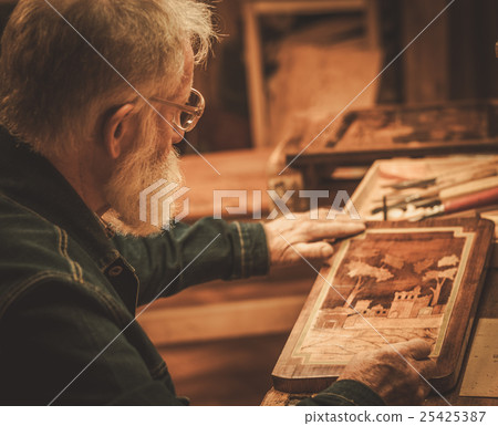Senior restorer working with antique decor element 25425387