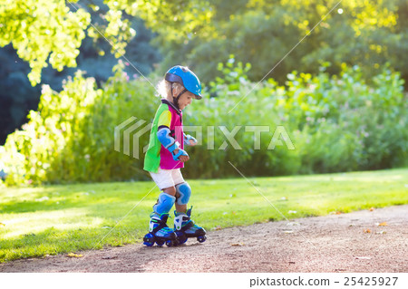 Kids roller skating in summer park Kids roller skating in summer park 25425927
