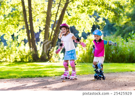 Kids roller skating in summer park 25425929