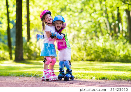 Kids roller skating in summer park Kids roller skating in summer park 25425930