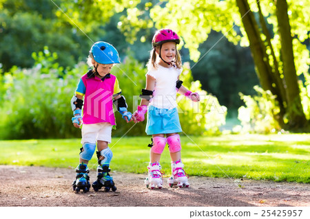 Kids roller skating in summer park Kids roller skating in summer park 25425957