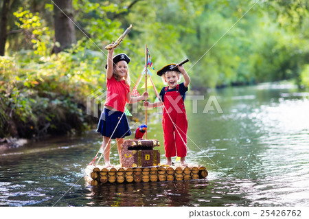 Kids playing pirate adventure on wooden raft 25426762
