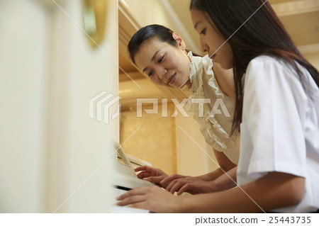 School girls playing the piano 25443735